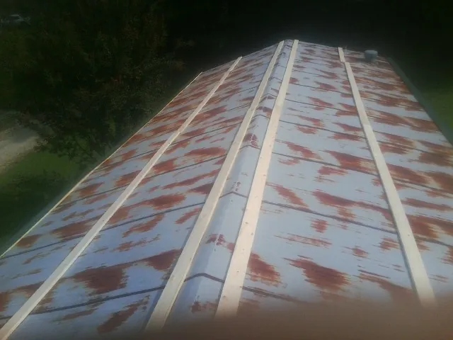 Rusted metal roof panels with new wood purlins before replacement — Storm Damage Roof Repair in Wrenshall by Roofing Brothers