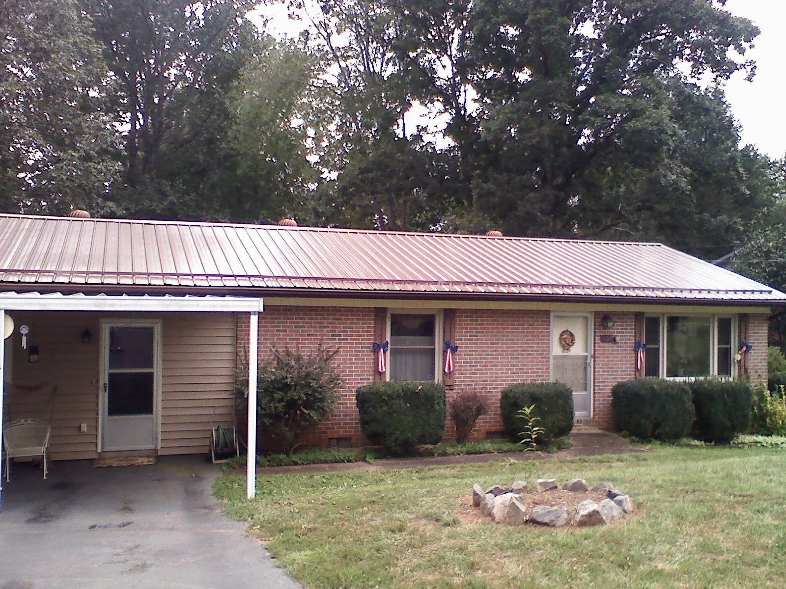 Bronze metal roof and carport on a brick ranch home — Roof Repair work by our crew in Wrenshall